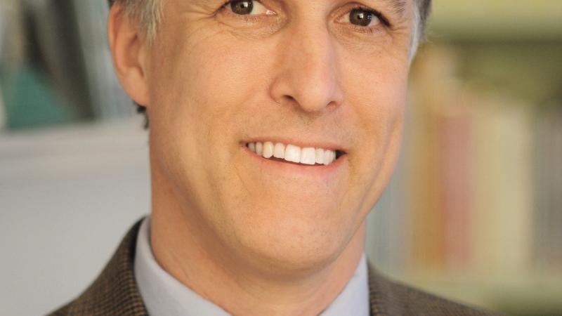 Color photo portrait of Erik Jorgensen in a suit and tie.