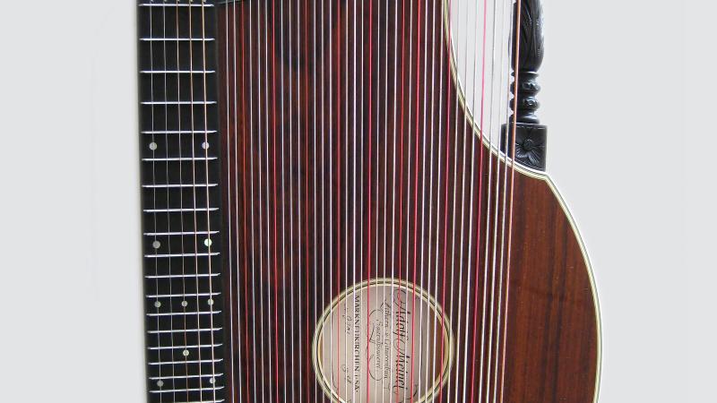 A stringed zither made of red-brown wood