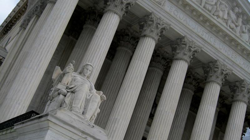 Looking from below up at the supreme court building, with its statue of lady justice on the left