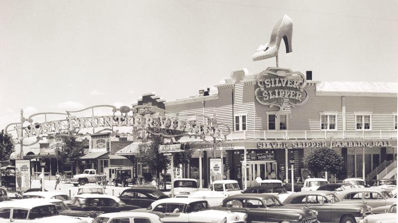 black and white photo of a parking lot, building in background