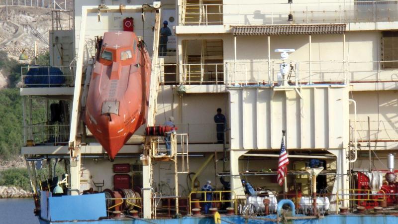 Photograph of a boat lowering a submarine into water