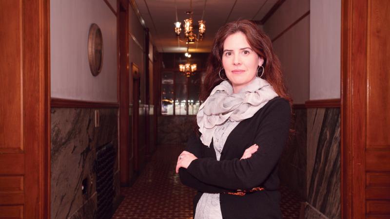 Photograph of a woman standing in a hallway