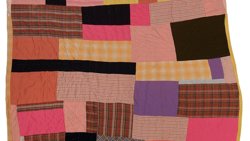 Photograph of a quilt made with various fabrics 