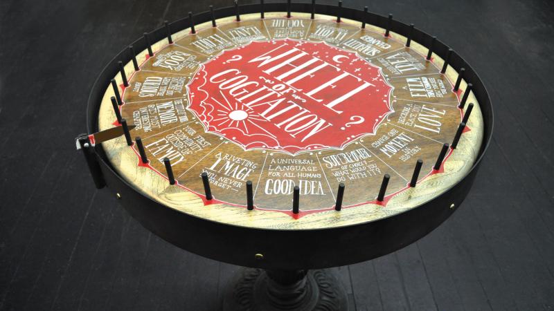 Color photo of a roulette wheel with various quirky instructions at each stop.