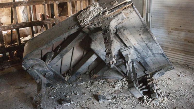 Dusty, run down wooden remains of a piano