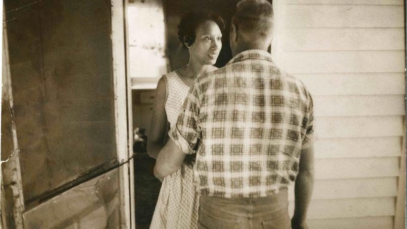 Sepia-colored photo of a man and woman in a doorway.