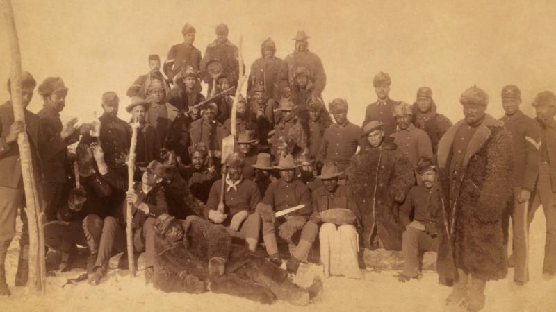 Sepia-colored photo portrait of an African-American infantry unit from the late 19th century.