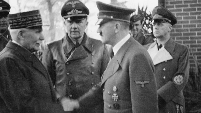 Black and white photo of Marshal Petain and Adolf Hitler shaking hands.