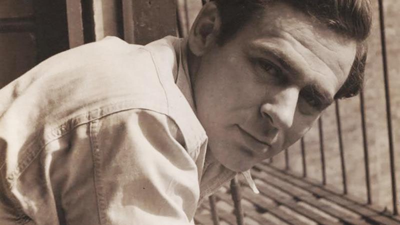 Sepia-colored photo portrait of James Agee leaning in at an angle.