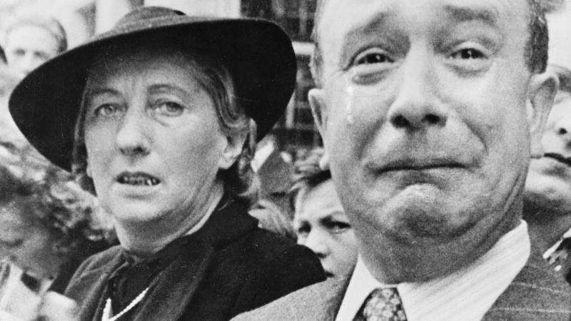 Black and white photo of a man and woman weeping in Paris due to the German occupation.