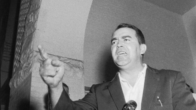 Black and white photo of Asa Carter giving an impassioned speech while gesturing with his finger.