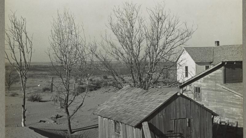 Black and white photo of houses in Kansas that have been overrun by drifts of sand.