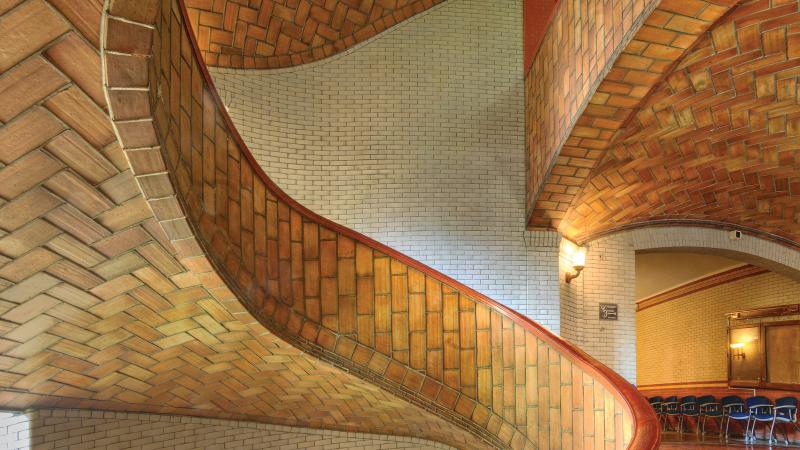 Photo of an ornate, red brick spiral staircase.