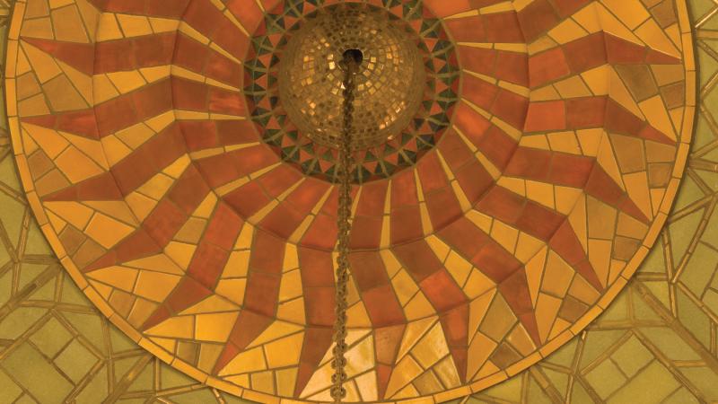 Photo of a beautiful round tile ceiling composed of yellow, orange, and red tiles.