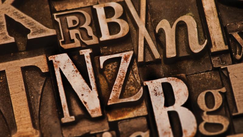 Assorted letters in shades of brown, on a bronze background