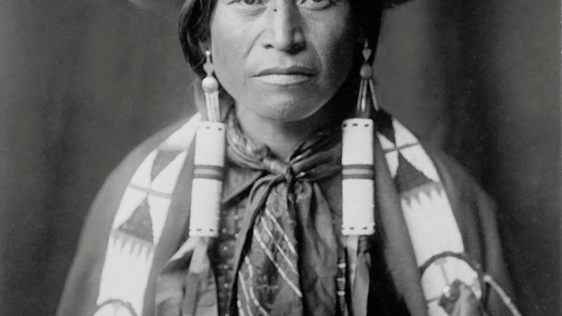 Black and white photo of apache cowboy in hat and scarf