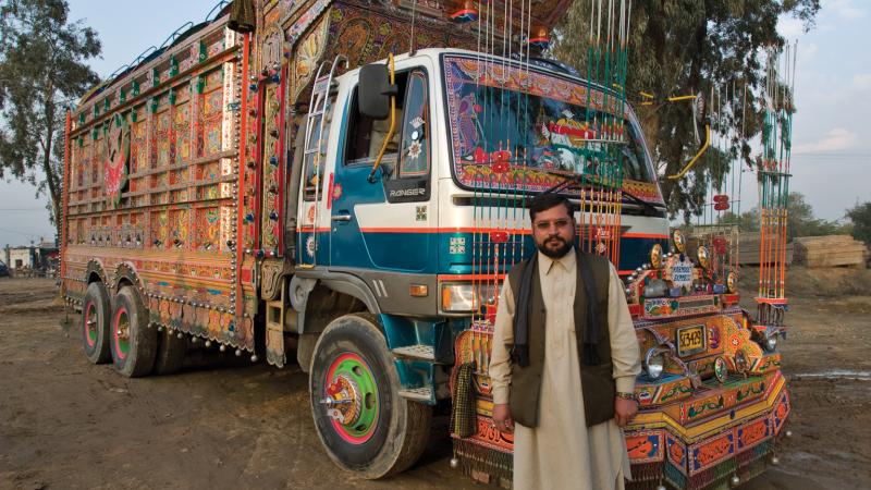 Pakistani man standing in front of a truck
