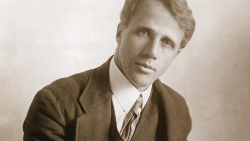 Sepia-colored photograph of a handsome Robert Frost in suit and tie.