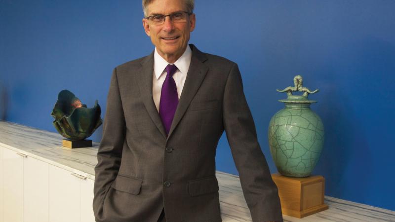 Color photo of William Adams wearing a suit and tie in a standing pose.