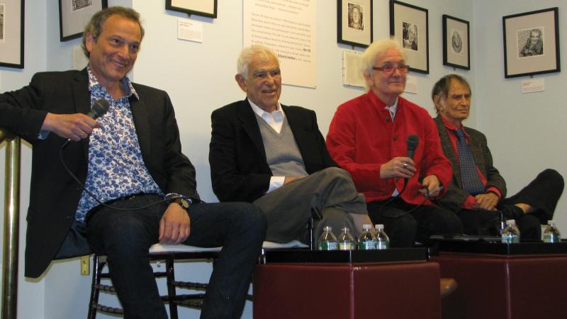 Four panelists sit on a small stage