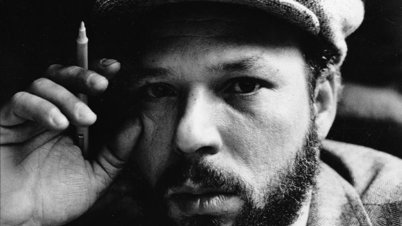 Black and white close-up of August Wilson sporting a beret in an intellectual pose.