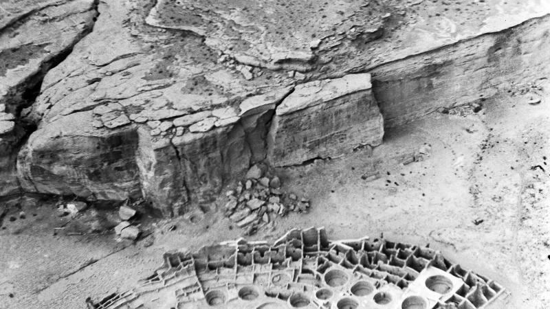 Black and white aerial photo of archaeological ruins in a desert canyon-like area.