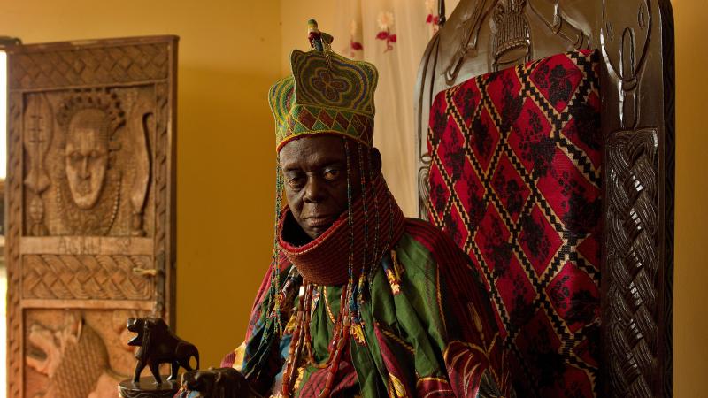 Ruler seated on a throne, wearing traditional royal clothing and crown