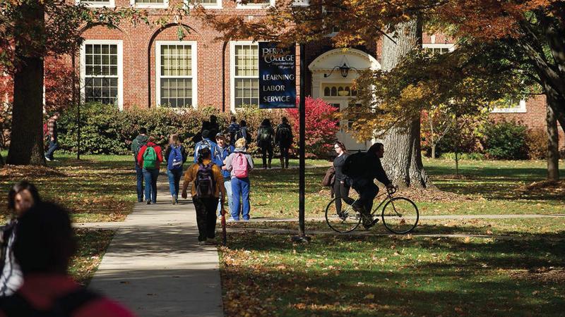 Students walking and biking in a green part of campus