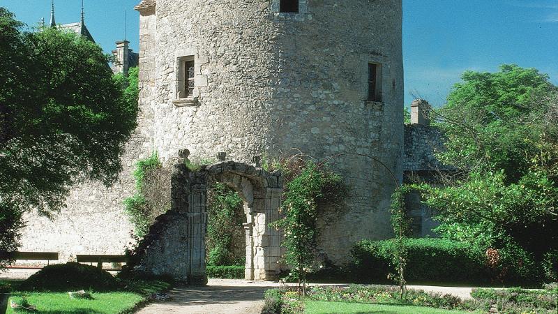 Photo of a cylindrical tower dwelling set in a verdant landscape.