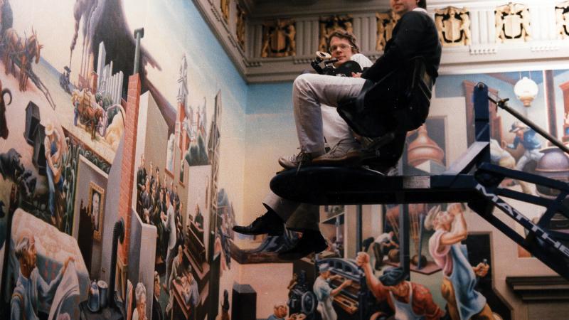 Color photo of Ken Burns on a movie set, elevated atop a camera platform.
