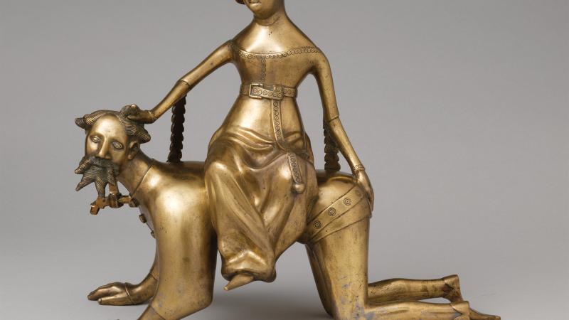 Gold figure of Phyllis riding atop an Aristotle on all fours, as if he were a dog.