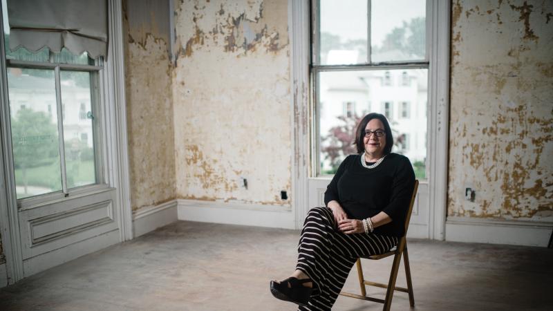 Photo of a woman sitting in a chair in an empty room
