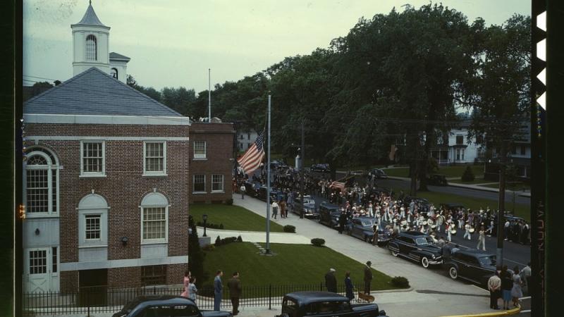 photograph of a town parade and town hall