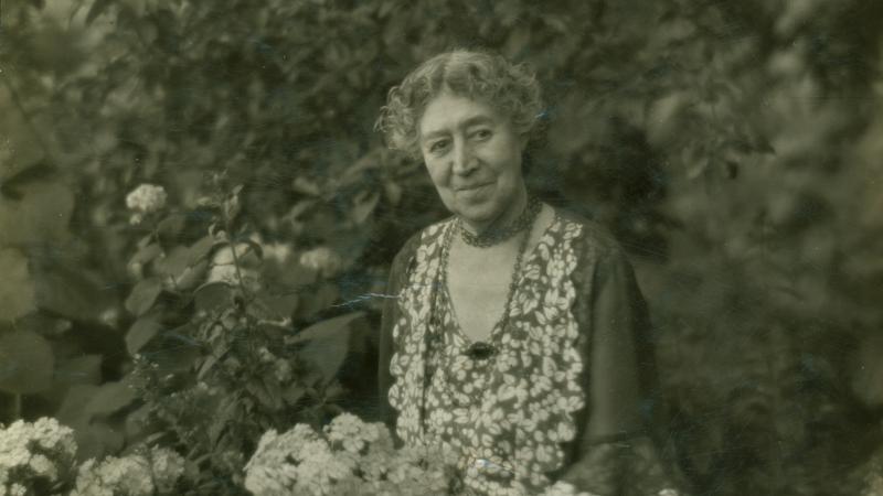 Photograph of a woman sitting in a garden