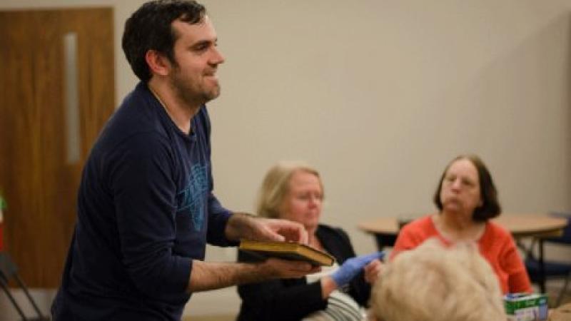 man standing up in front of a group of people