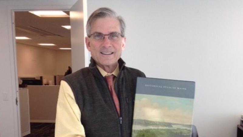 NEH Chairman William "Bro" Adams holding the Historical Atlas of Maine.