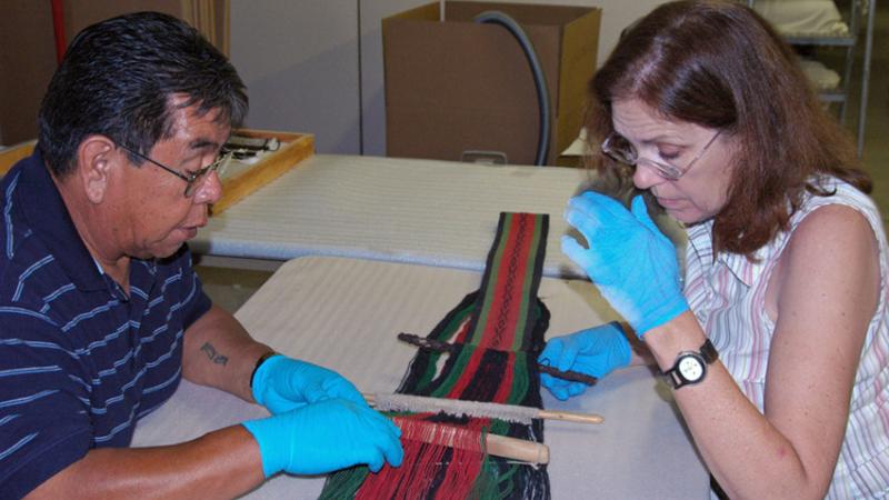 Conservator and Hopi weaver working on a piece