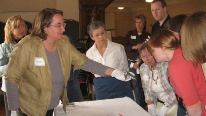 photograph of people leaning over a table