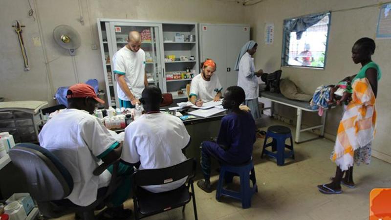 Photograph of clinic with various doctors working around a table