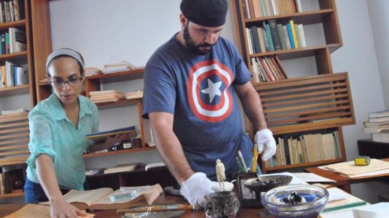 photograph of a man and woman performing preservation work at table