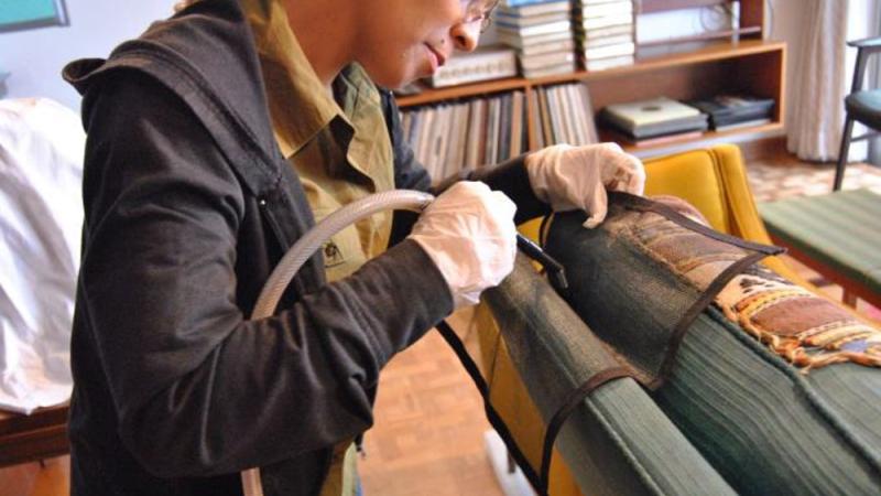 Woman standing and doing preservation work on a piece of fabric