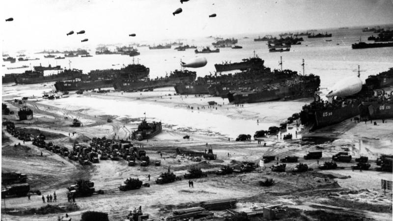 Ships put cargo ashore during low tide in the early days of the Normandy invasion.