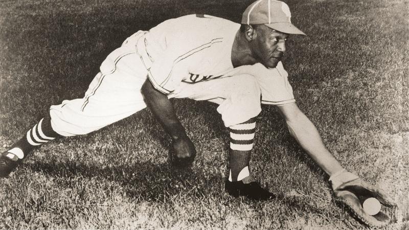 Black and white photo of Buck O'Neal reaching for a ground ball.
