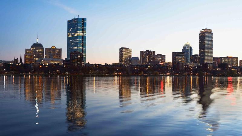 Photo of the Boston skyline reflected in the waterfront.