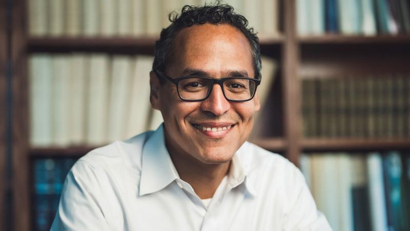 Photo of Roosevelt Montás in a library. 