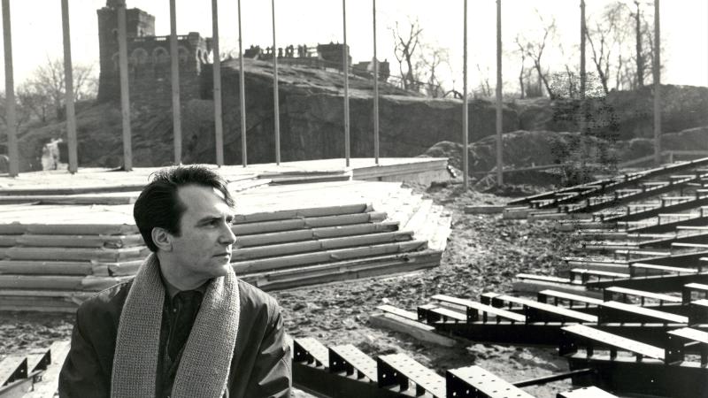 Black and white photo of Joe Papp in front of empty Delacorte outdoor theater