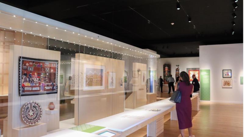 Visitors admire the renovated Eiteljorg Native American galleries, including textiles and art displayed in new glass cases.