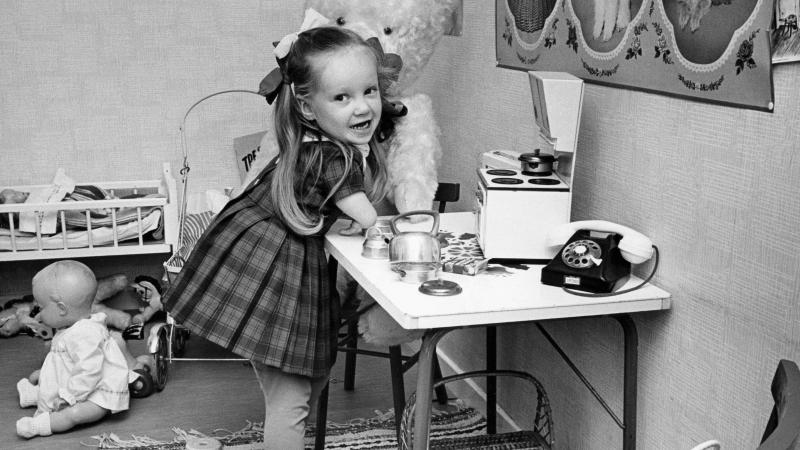 A young thalidomide victim plays in her toy kitchen.