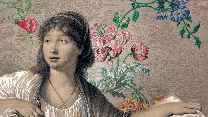 Girl holding a drawing before a floral wall