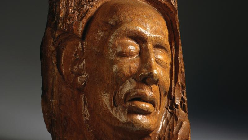 wood relief sculpture of a grieving face